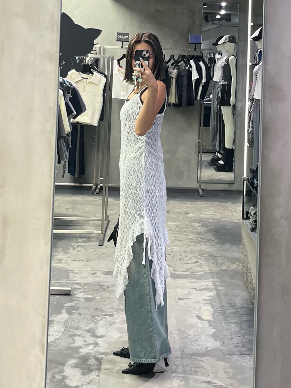 ブルー系のデニムパンツ、ブラック系のパンプス、ブラック系のニット/セーターを着用したレディースの夏コーディネートの2枚目の写真