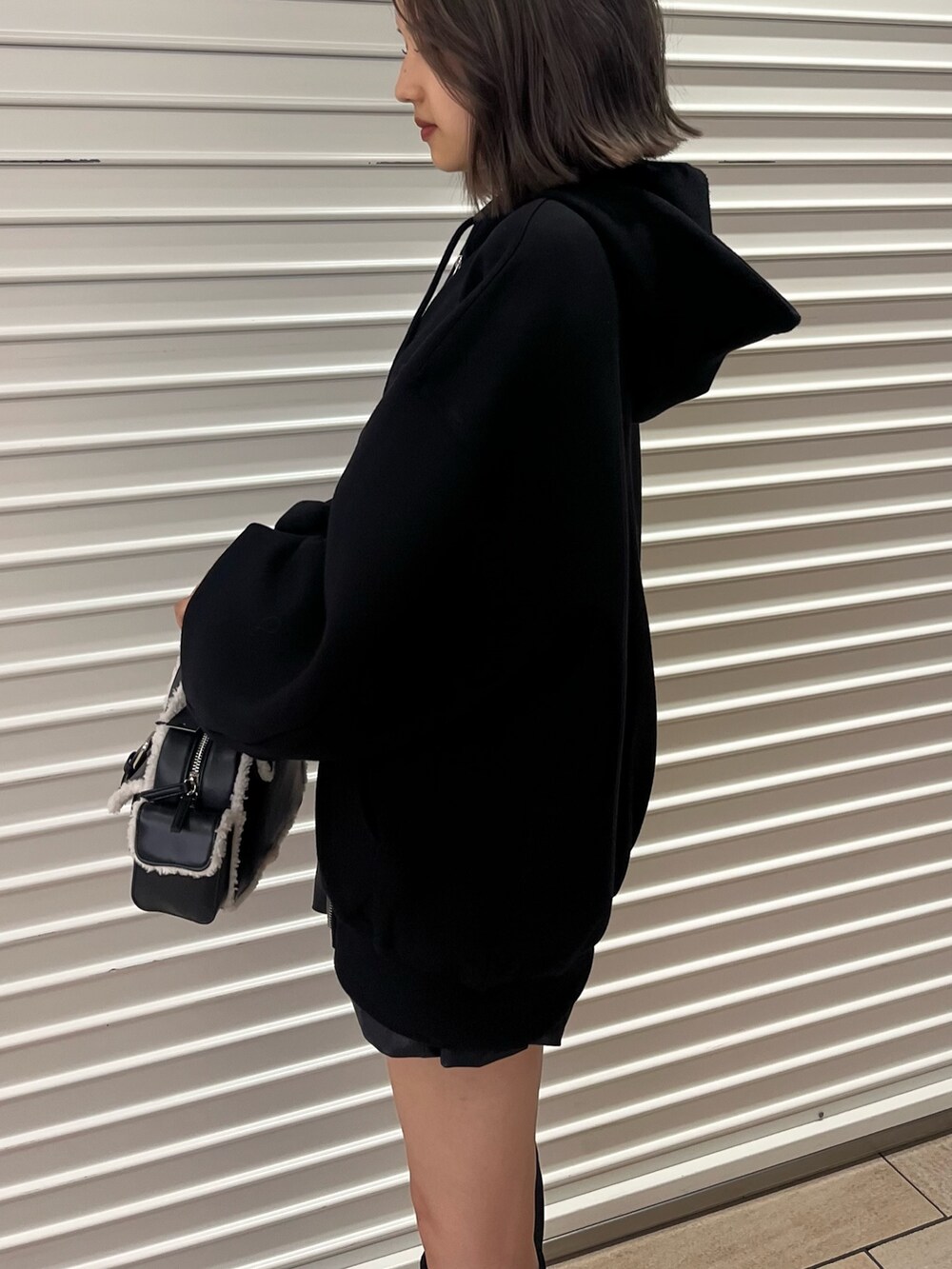 その他のスカート、ブラック系のハンドバッグ、ブラック系のブーツを着用したレディースの秋コーディネートの4枚目の写真