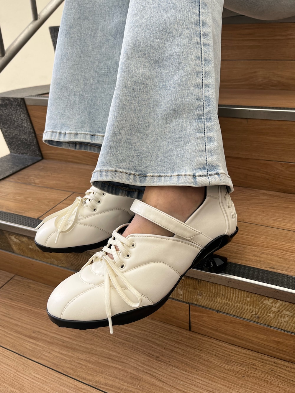 ブルー系のデニムパンツ、ホワイト系のスニーカー、イエロー系のニット/セーターを着用したレディースの春コーディネートの7枚目の写真