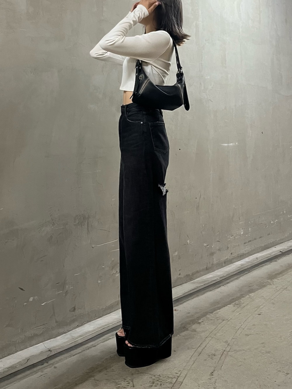 ホワイト系のTシャツ/カットソー、ブラック系のハンドバッグ、ブラック系のデニムパンツを着用したレディースの秋コーディネートの2枚目の写真