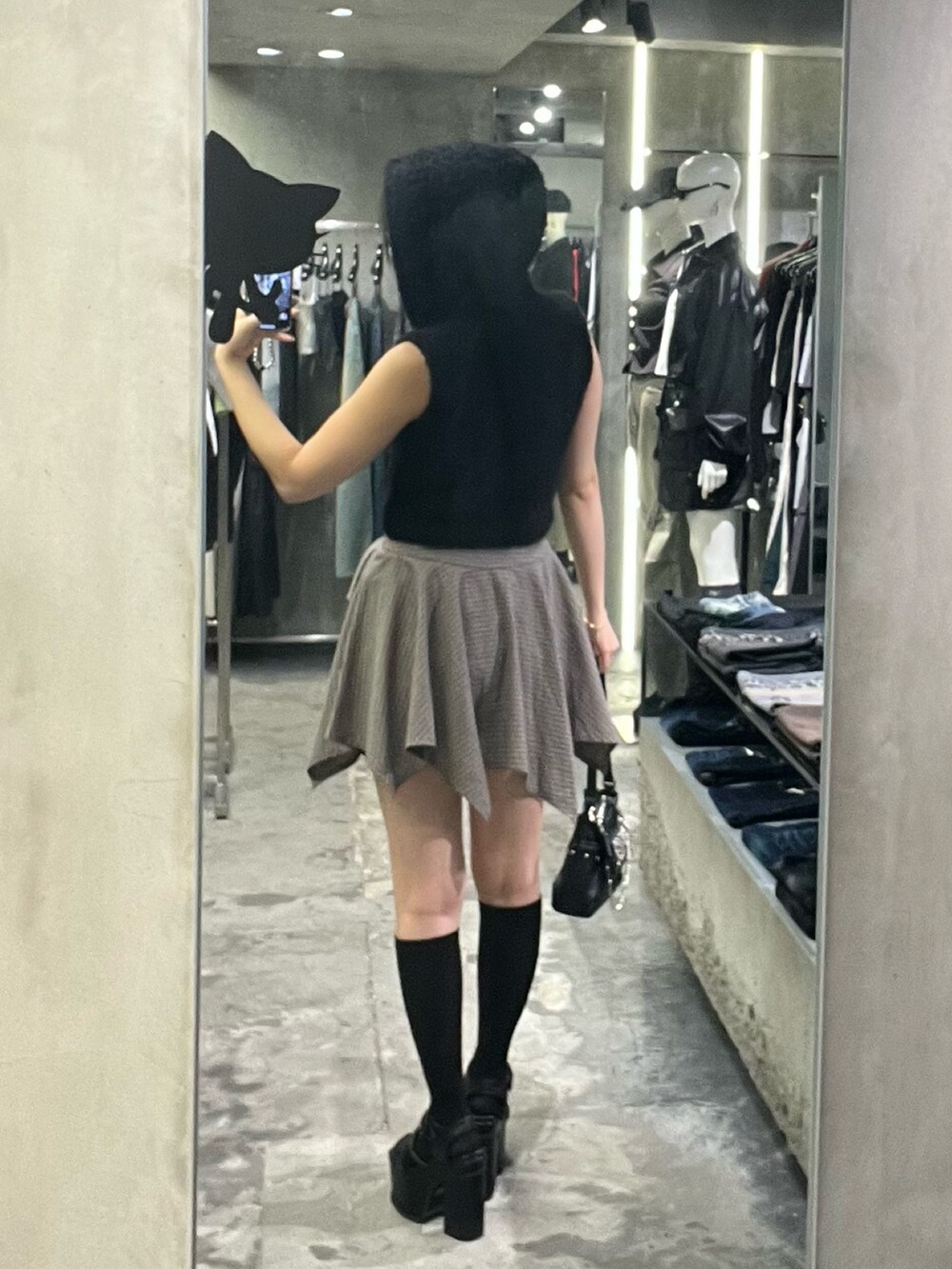 ブラック系のニット/セーター、ブラック系のハンドバッグ、ブラック系のサンダルを着用したレディースの春コーディネートの3枚目の写真