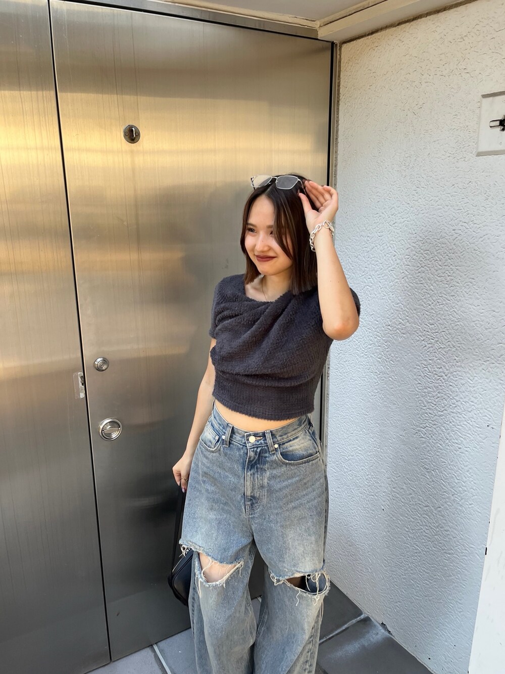 ブラック系のブーツ、グレー系のTシャツ/カットソー、ブラック系のハンドバッグを着用したレディースの夏コーディネートの4枚目の写真