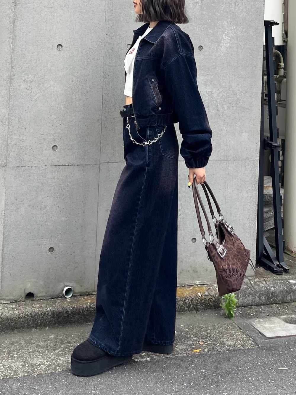 ブルー系のブルゾン、ホワイト系のTシャツ/カットソー、ブラウン系のショルダーバッグを着用したレディースの夏コーディネートの2枚目の写真