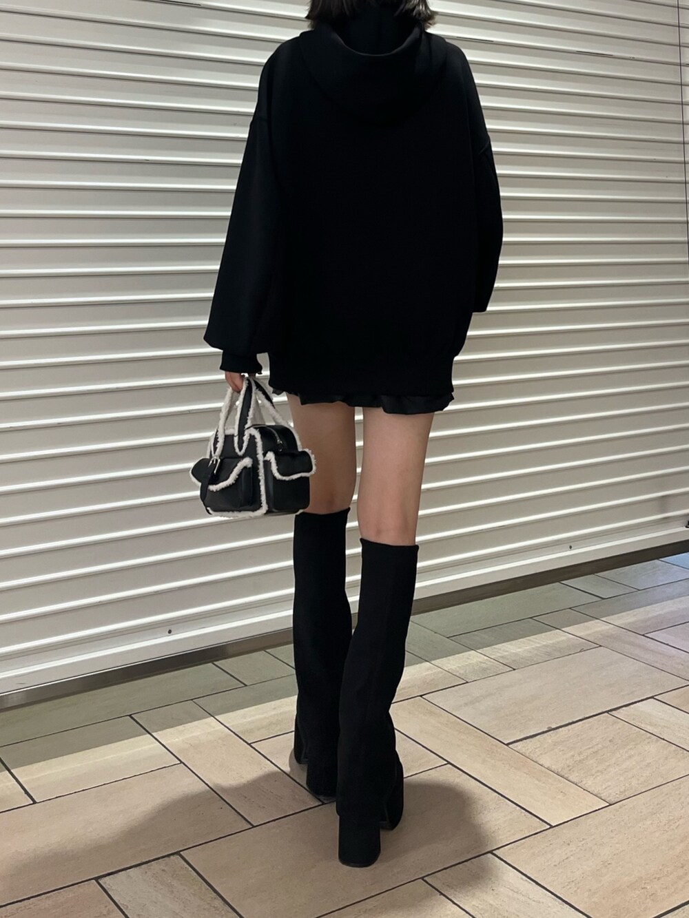 その他のスカート、ブラック系のハンドバッグ、ブラック系のブーツを着用したレディースの秋コーディネートの3枚目の写真