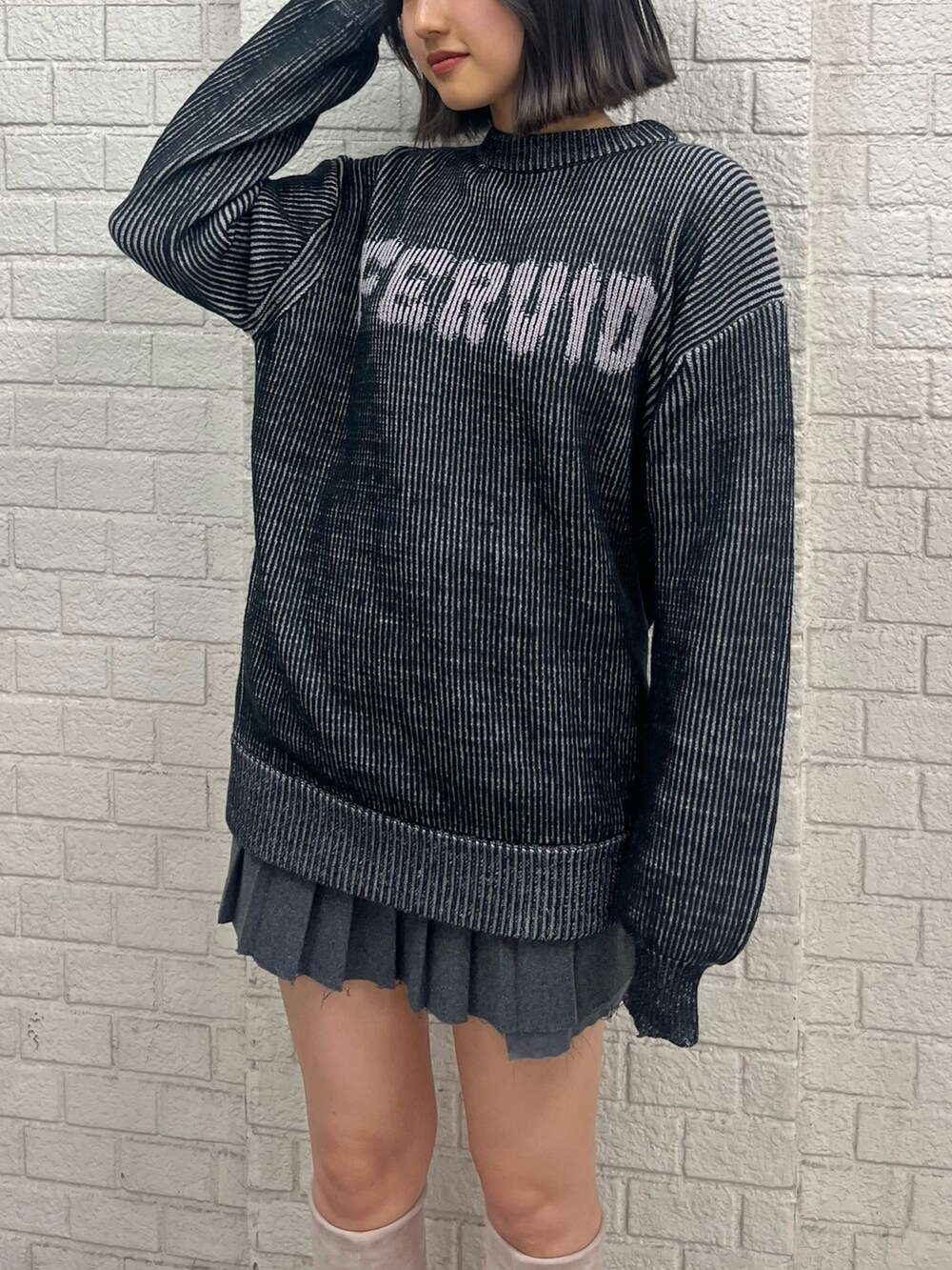 ブラック系のニット/セーター、グレー系のスカート、ホワイト系のブーツを着用したレディースの秋コーディネートの4枚目の写真