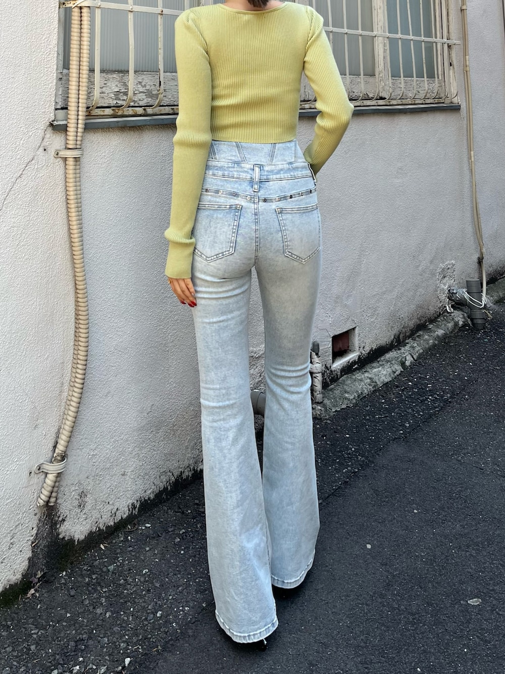 ブルー系のデニムパンツ、ホワイト系のスニーカー、イエロー系のニット/セーターを着用したレディースの春コーディネートの3枚目の写真
