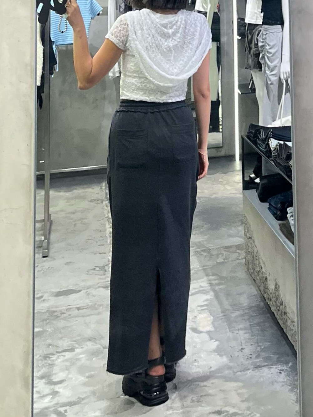 グレー系のサンダル、ブラック系のスカート、ホワイト系のキャミソールを着用したレディースの夏コーディネートの3枚目の写真