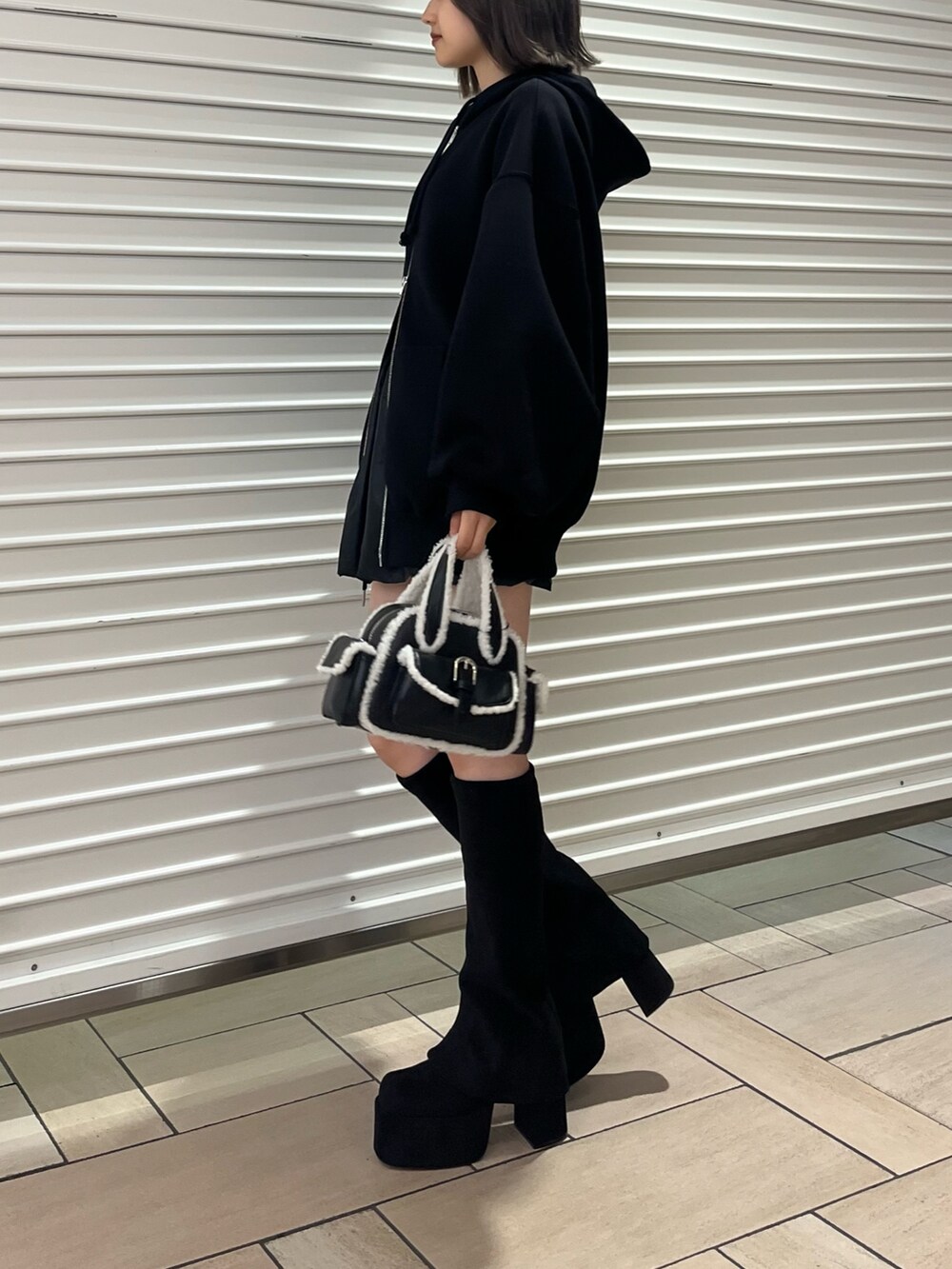 その他のスカート、ブラック系のハンドバッグ、ブラック系のブーツを着用したレディースの秋コーディネートの2枚目の写真