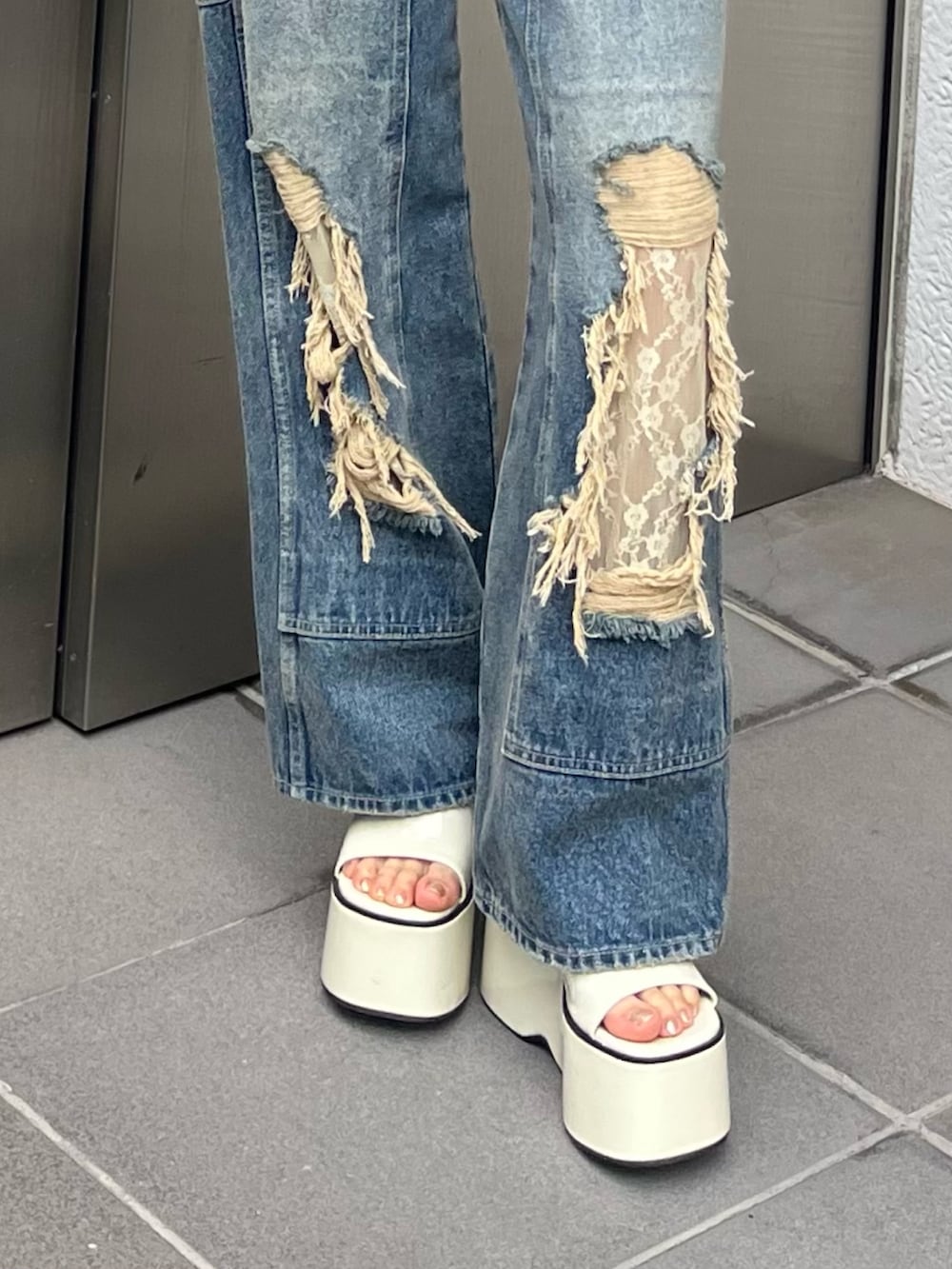 ホワイト系のサンダル、ベージュ系のTシャツ/カットソー、ブルー系のデニムパンツを着用したレディースの春コーディネートの3枚目の写真