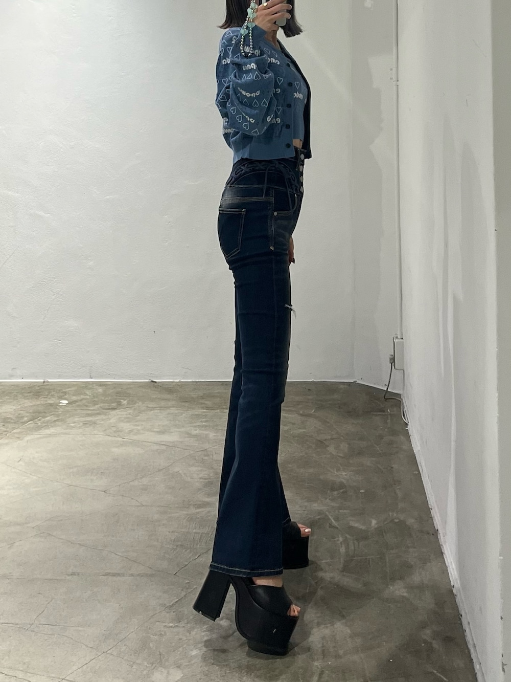 ブルー系のニット/セーター、ブルー系のデニムパンツ、ブラック系のサンダルを着用したレディースの冬コーディネートの2枚目の写真