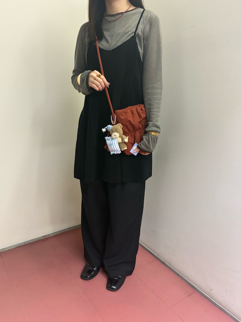 レッド系のショルダーバッグ、グレー系のTシャツ/カットソー、ブラック系のワンピースを着用したレディースの秋コーディネートの2枚目の写真