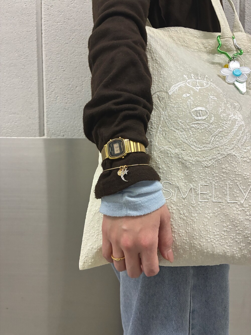 ホワイト系のトートバッグ、ゴールド系のブレスレット、ゴールド系のリングを着用したレディースの冬コーディネートの2枚目の写真