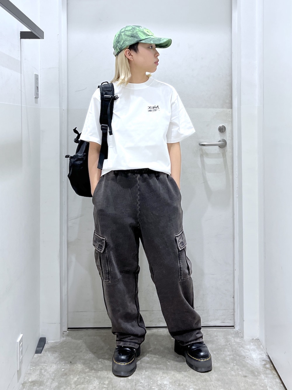 ブラック系のバックパック/リュック、ホワイト系のTシャツ/カットソー、ブラック系のスウェットパンツを着用したレディースの冬コーディネートの2枚目の写真