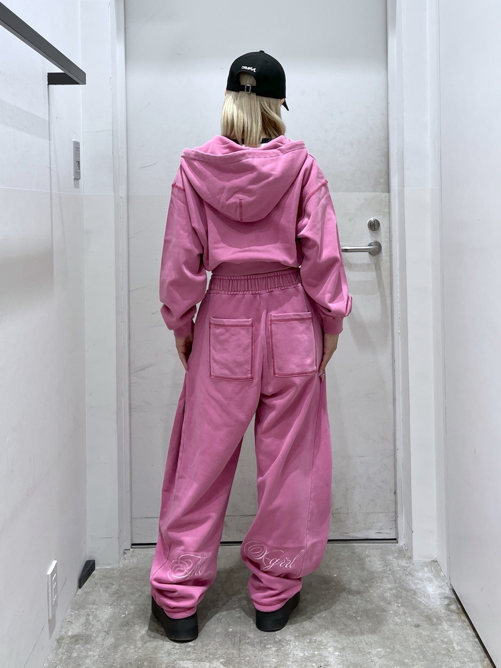 ピンク系のスウェットパンツ、ピンク系のパーカー、ホワイト系のTシャツ/カットソーを着用したレディースの春コーディネートの2枚目の写真