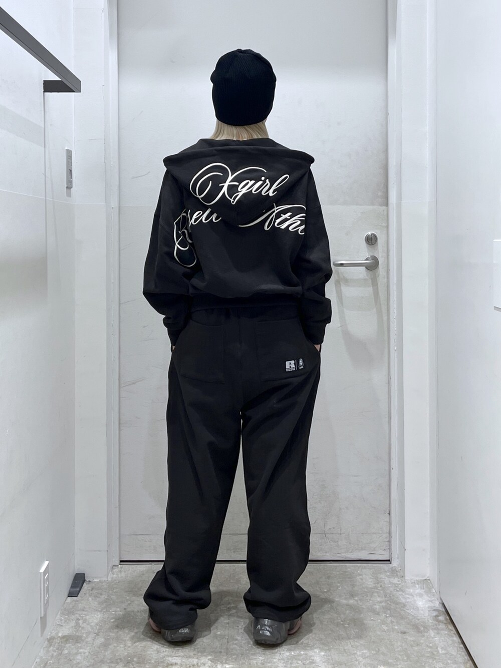 ブラック系のスウェットパンツ、ブラック系のパーカー、ホワイト系のTシャツ/カットソーを着用したレディースの冬コーディネートの2枚目の写真