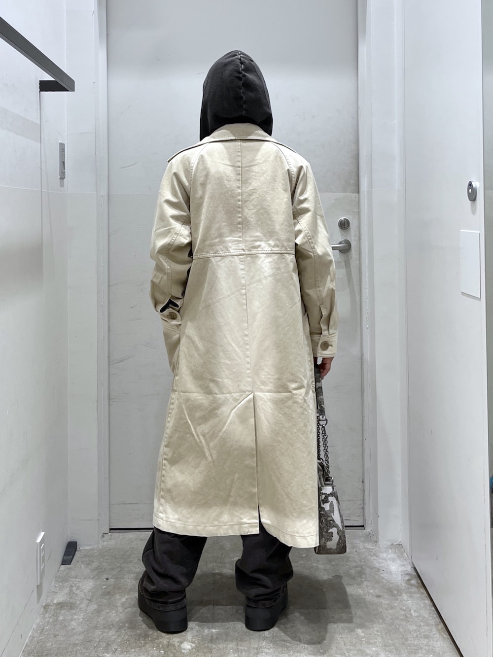 ブラック系のパーカー、ブラック系のスウェットパンツ、ベージュ系のトレンチコートを着用したレディースの冬コーディネートの2枚目の写真