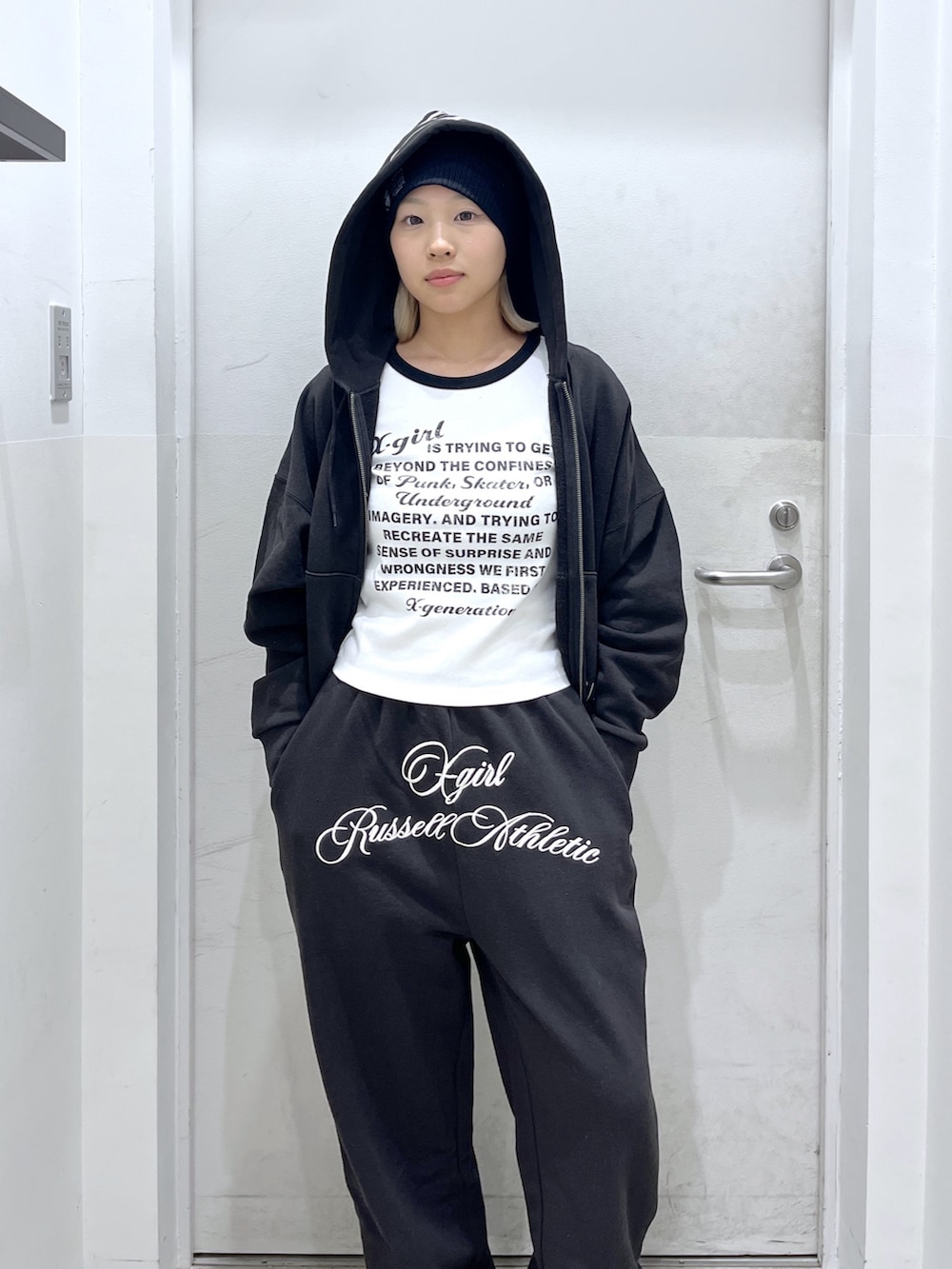 ブラック系のスウェットパンツ、ブラック系のパーカー、ホワイト系のTシャツ/カットソーを着用したレディースの冬コーディネートの4枚目の写真
