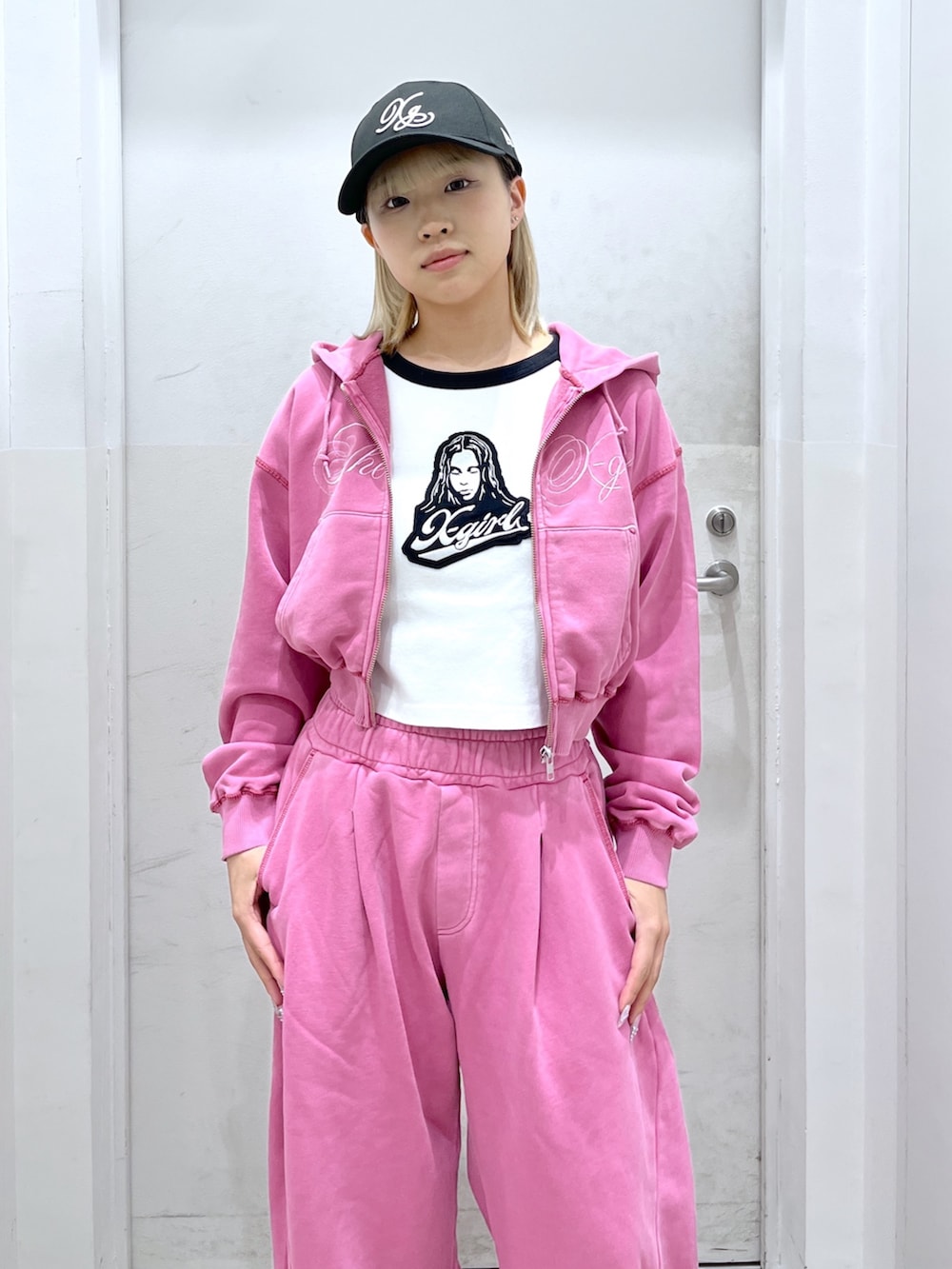 ピンク系のスウェットパンツ、ピンク系のパーカー、ホワイト系のTシャツ/カットソーを着用したレディースの春コーディネートの3枚目の写真