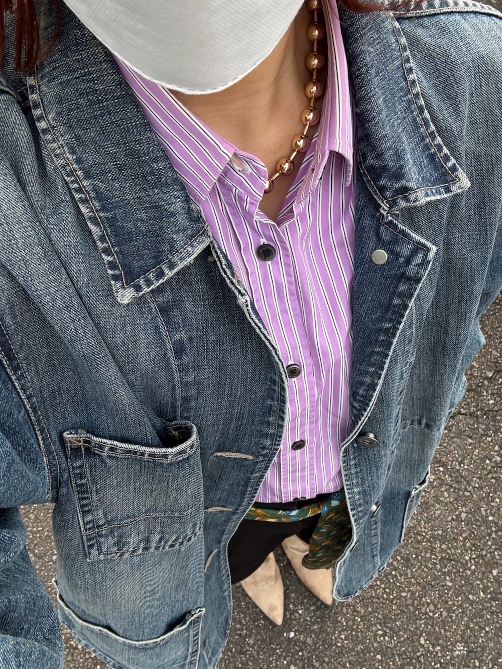 ブルー系のデニムジャケット、パープル系のシャツ/ブラウス、ブラック系のパンツを着用したレディースの秋コーディネートの2枚目の写真