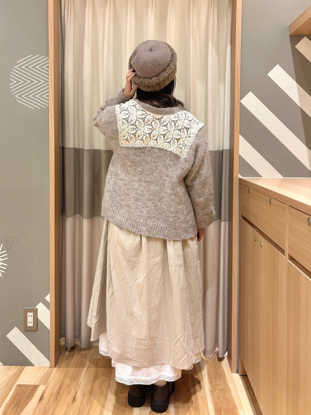 ブラウン系のドレスシューズ、ベージュ系のワンピース、ブラウン系のカーディガン/ボレロを着用したレディースの冬コーディネートの2枚目の写真