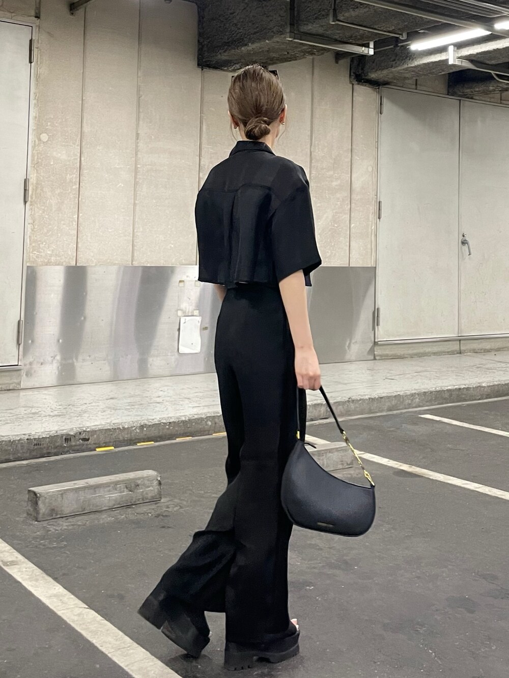 ブラック系のブーツ、ブラック系のその他パンツ、ホワイト系のニット/セーターを着用したレディースの夏コーディネートの4枚目の写真