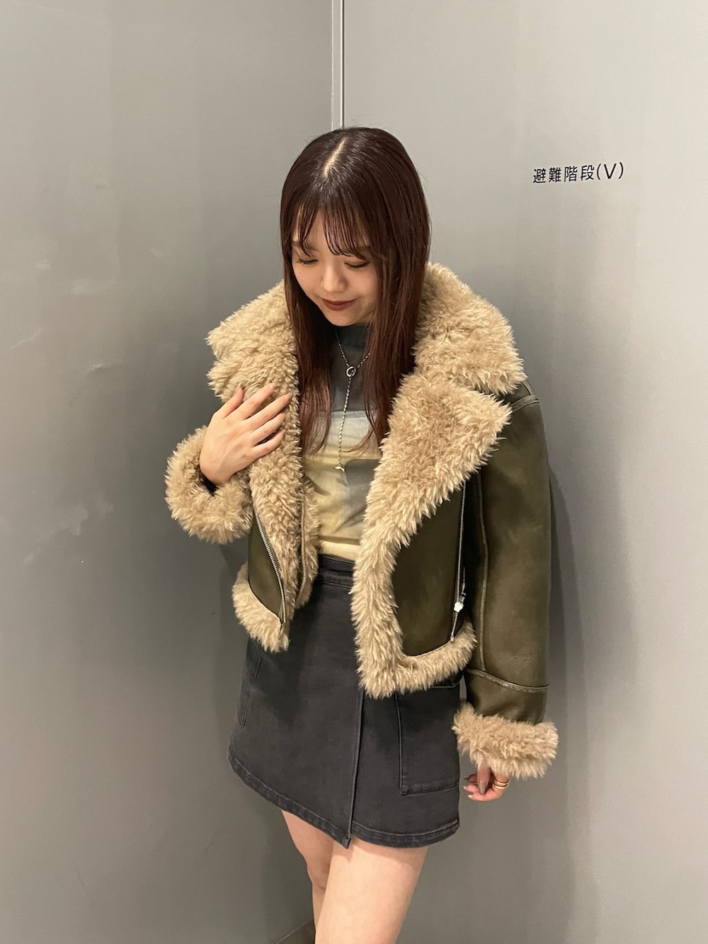 ブラック系のスカート、グリーン系のムートンコート、その他のTシャツ/カットソーを着用したレディースの夏コーディネートの5枚目の写真