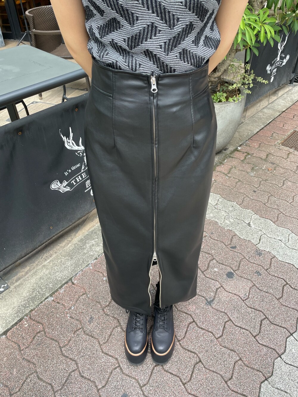 ブラック系のニット/セーター、ブラック系のスカート、ブラック系のブーツを着用したレディースの秋コーディネートの7枚目の写真