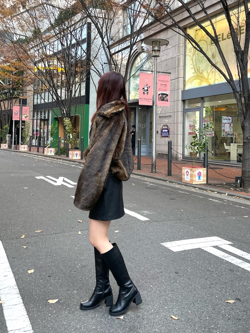 ブラック系のブーツ、ブラック系のスカート、レッド系のニット/セーターを着用したレディースの冬コーディネートの3枚目の写真