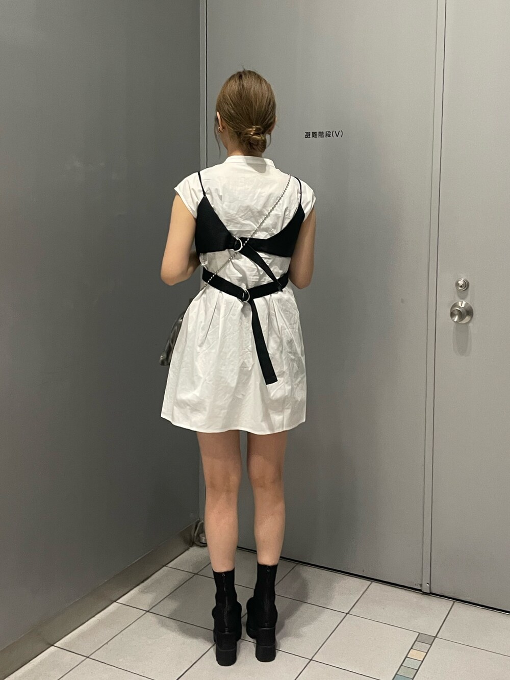 グレー系のショルダーバッグ、ブラック系のブーツ、ブラック系のワンピースを着用したレディースの春コーディネートの4枚目の写真