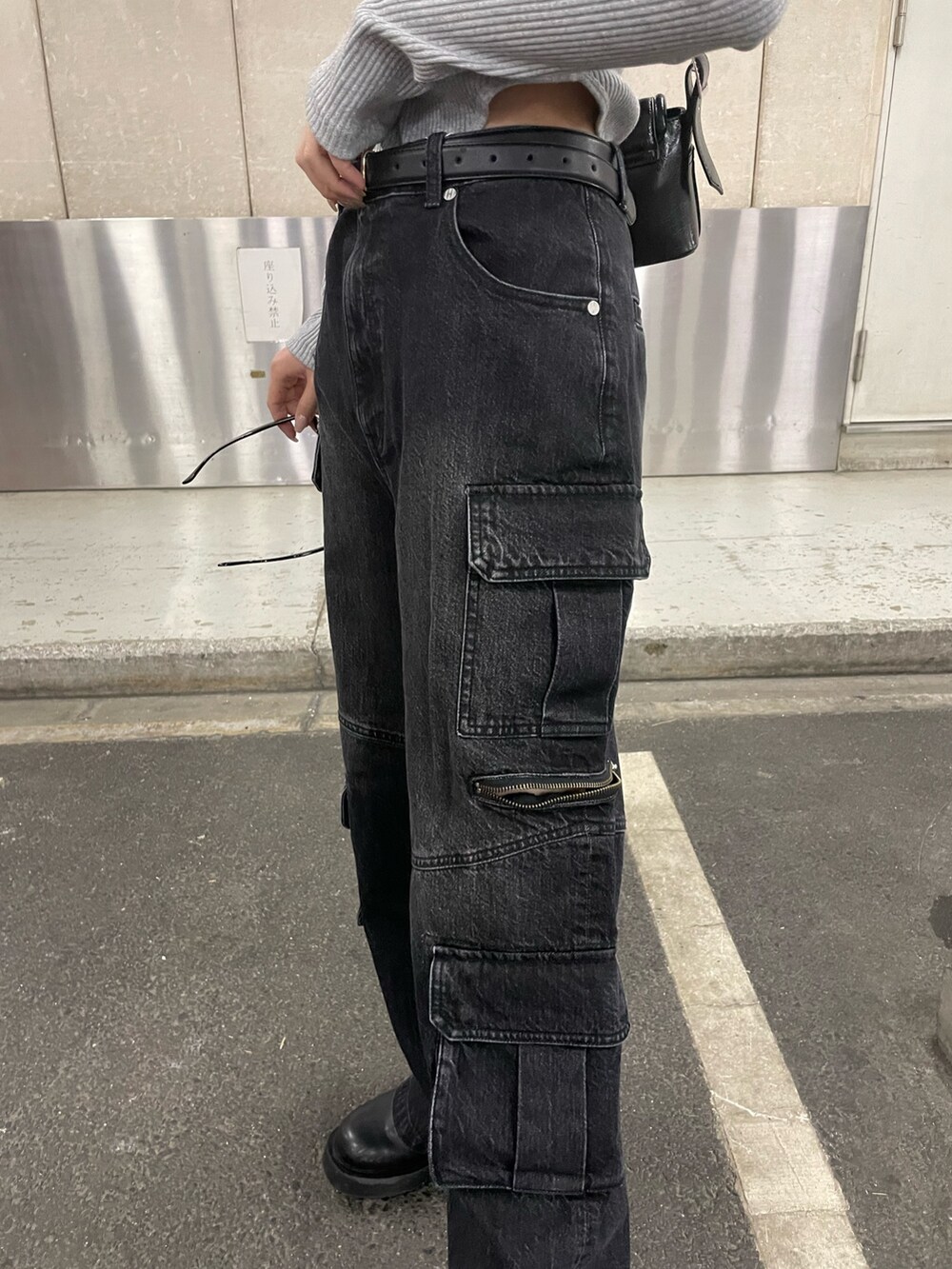 ブラック系のデニムパンツ、ブラック系のショルダーバッグ、グレー系のTシャツ/カットソーを着用したレディースの冬コーディネートの8枚目の写真