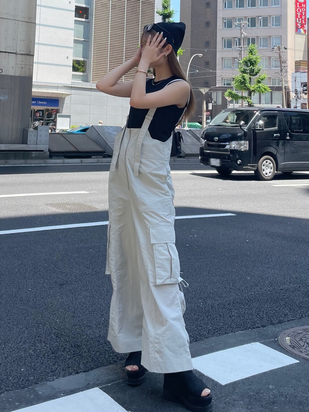 ホワイト系のつなぎ/オールインワン、ブラック系のTシャツ/カットソー、ブラック系のショルダーバッグを着用したレディースの夏コーディネートの2枚目の写真