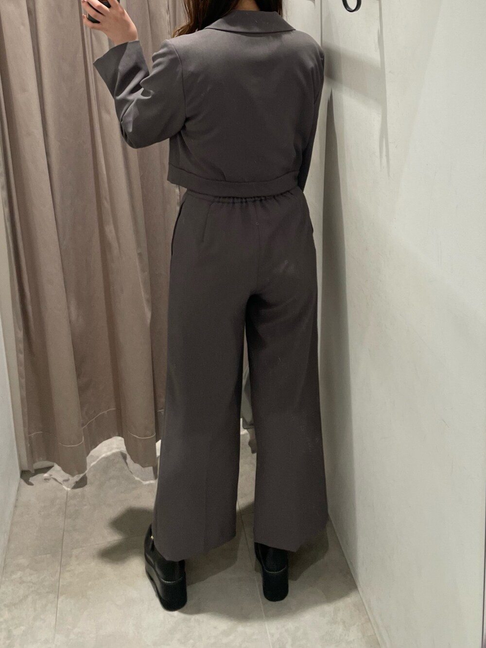 グレー系のテーラードジャケット、ブラック系のニット/セーター、シルバー系のハンドバッグを着用したレディースの春コーディネートの3枚目の写真