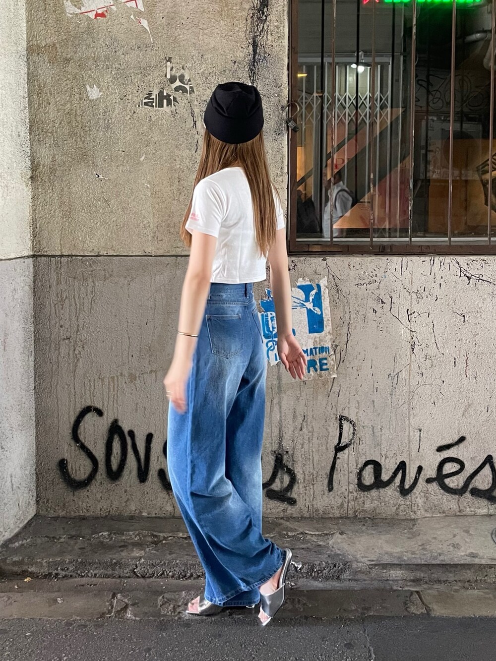 ブルー系のデニムパンツ、シルバー系のサンダル、ホワイト系のTシャツ/カットソーを着用したレディースの夏コーディネートの4枚目の写真