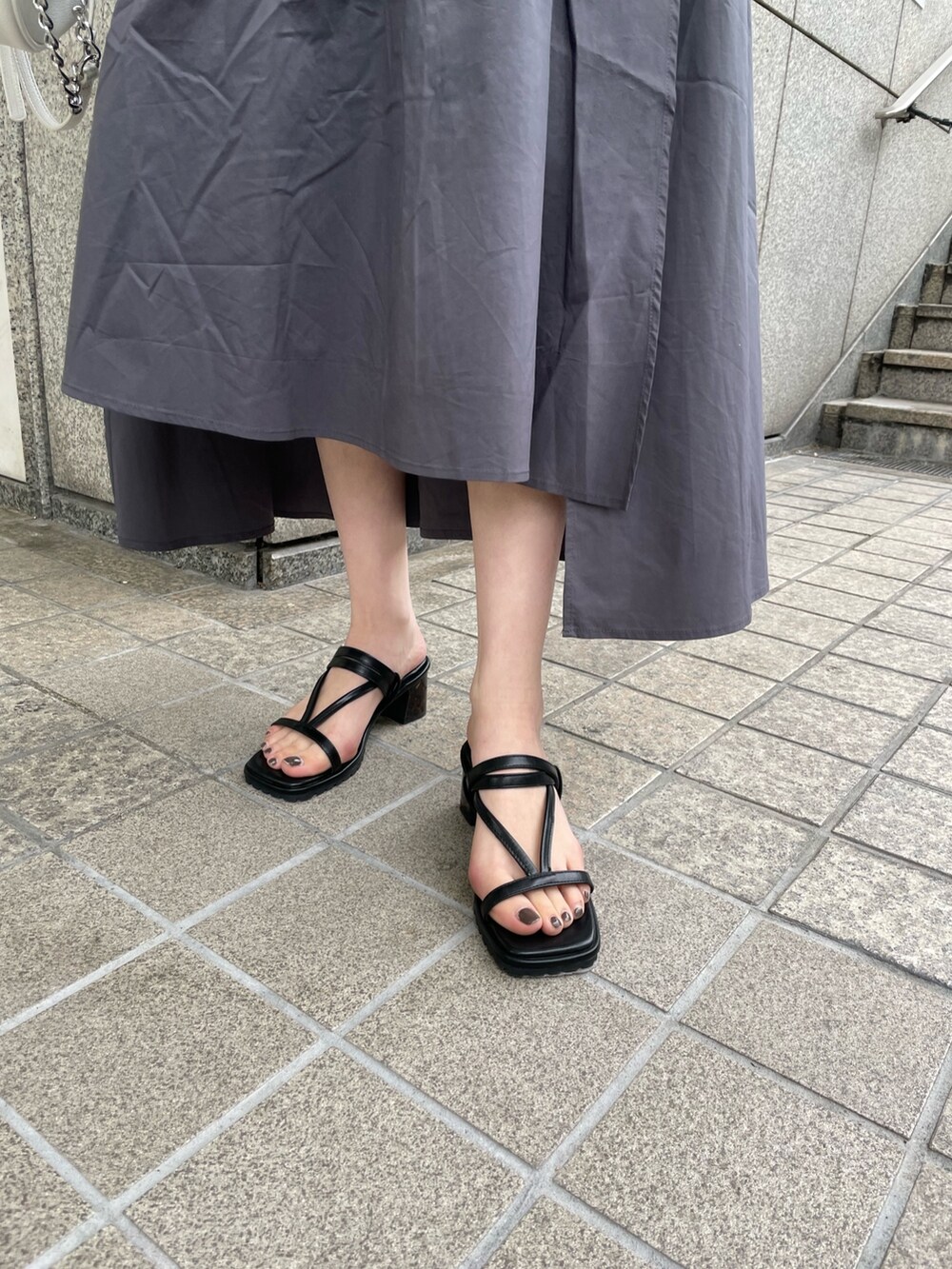 グレー系のワンピース、ブルー系のニット/セーター、ホワイト系のハンドバッグを着用したレディースの春コーディネートの6枚目の写真