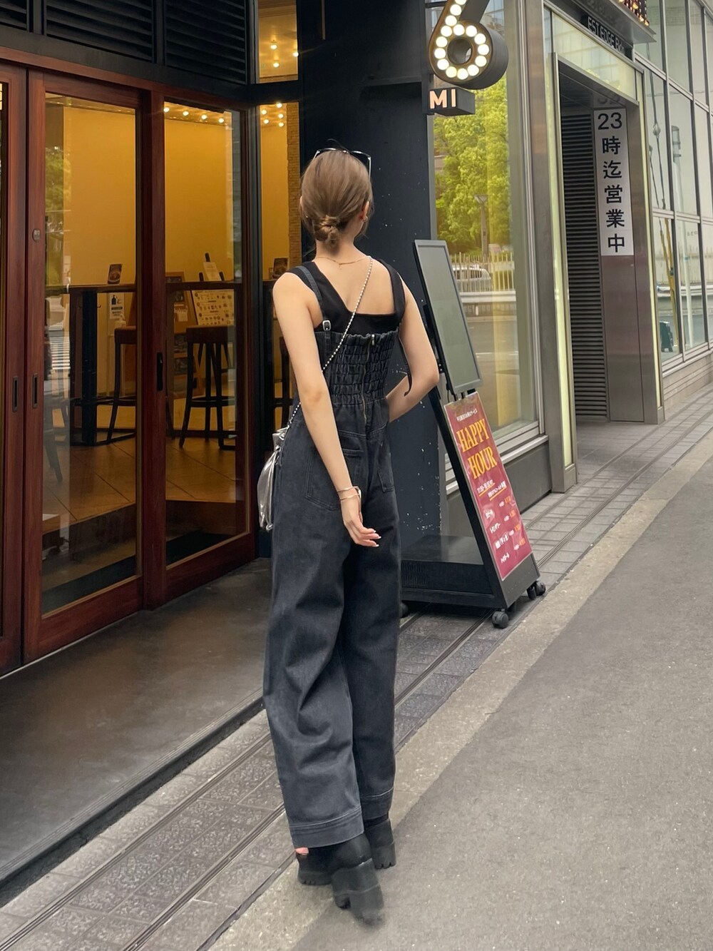 グレー系のショルダーバッグ、ブラック系のブーツ、ブラック系のニット/セーターを着用したレディースの春コーディネートの5枚目の写真