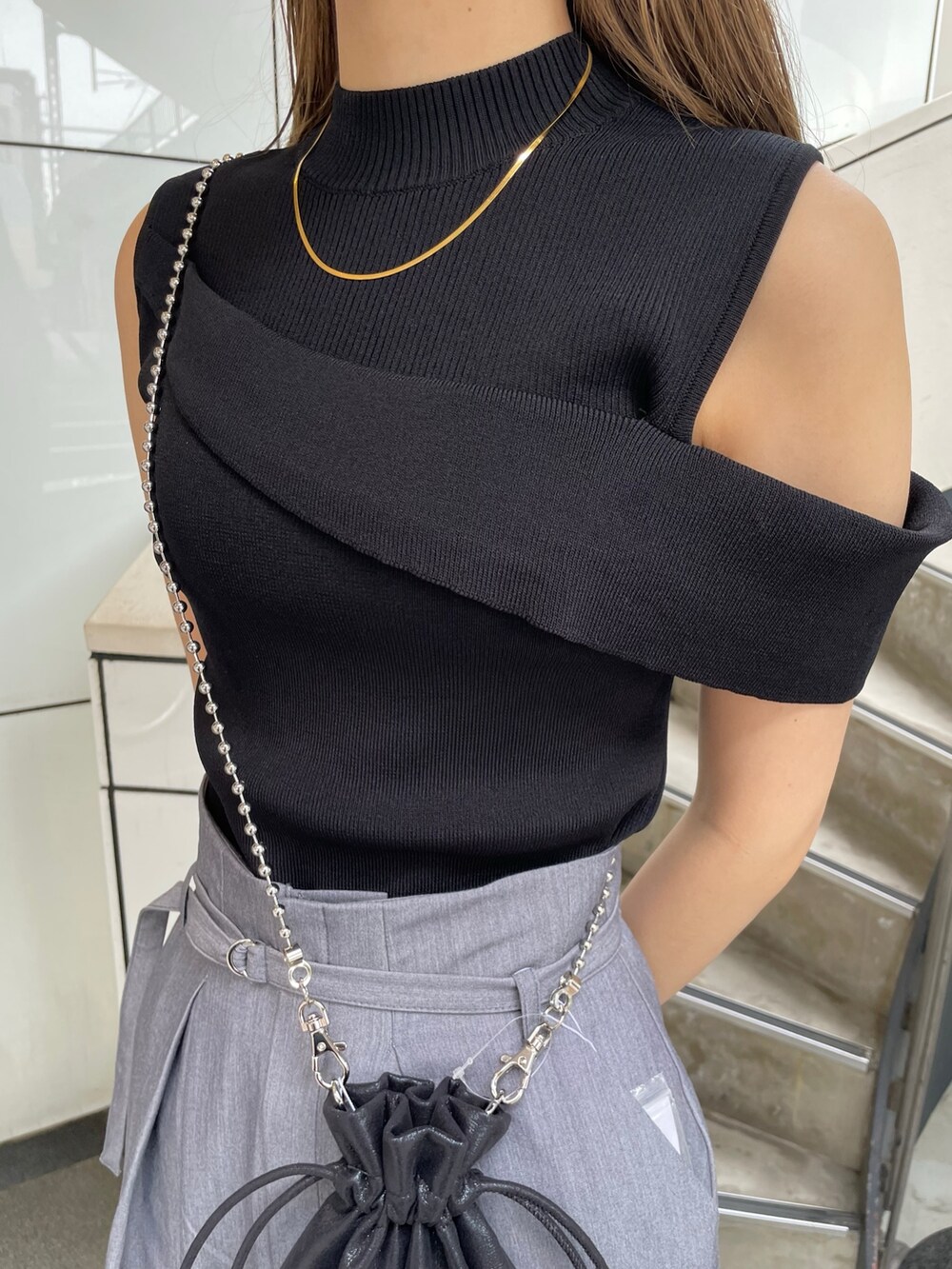 ブラック系のニット/セーター、ブラック系のショルダーバッグ、グレー系のその他パンツを着用したレディースの春コーディネートの6枚目の写真