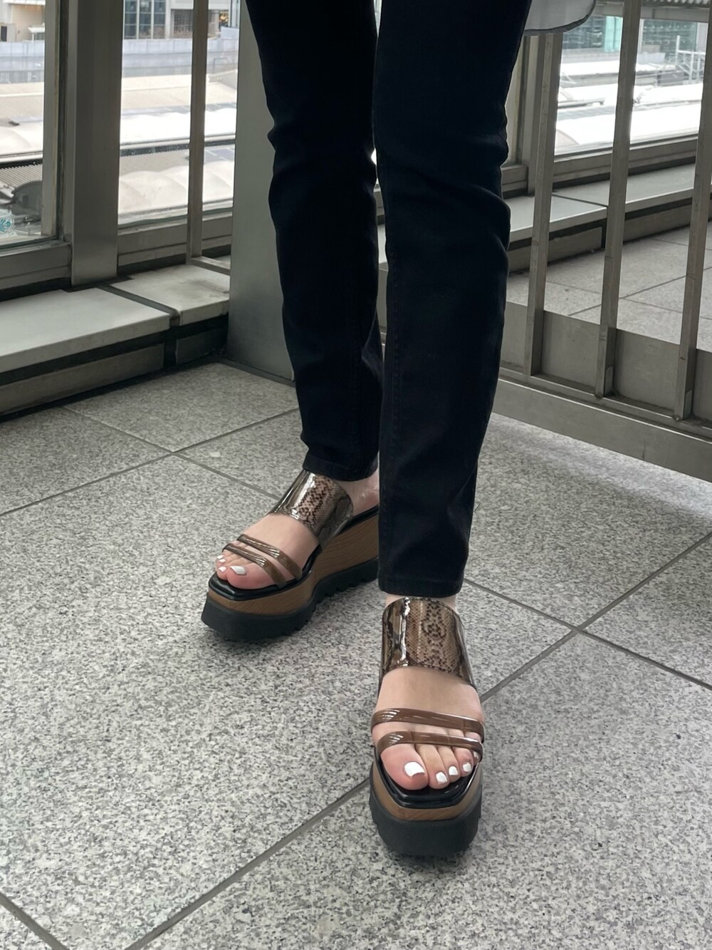 グレー系のシャツ/ブラウス、ブルー系のタンクトップ、ブラック系のハンドバッグを着用したレディースの春コーディネートの9枚目の写真