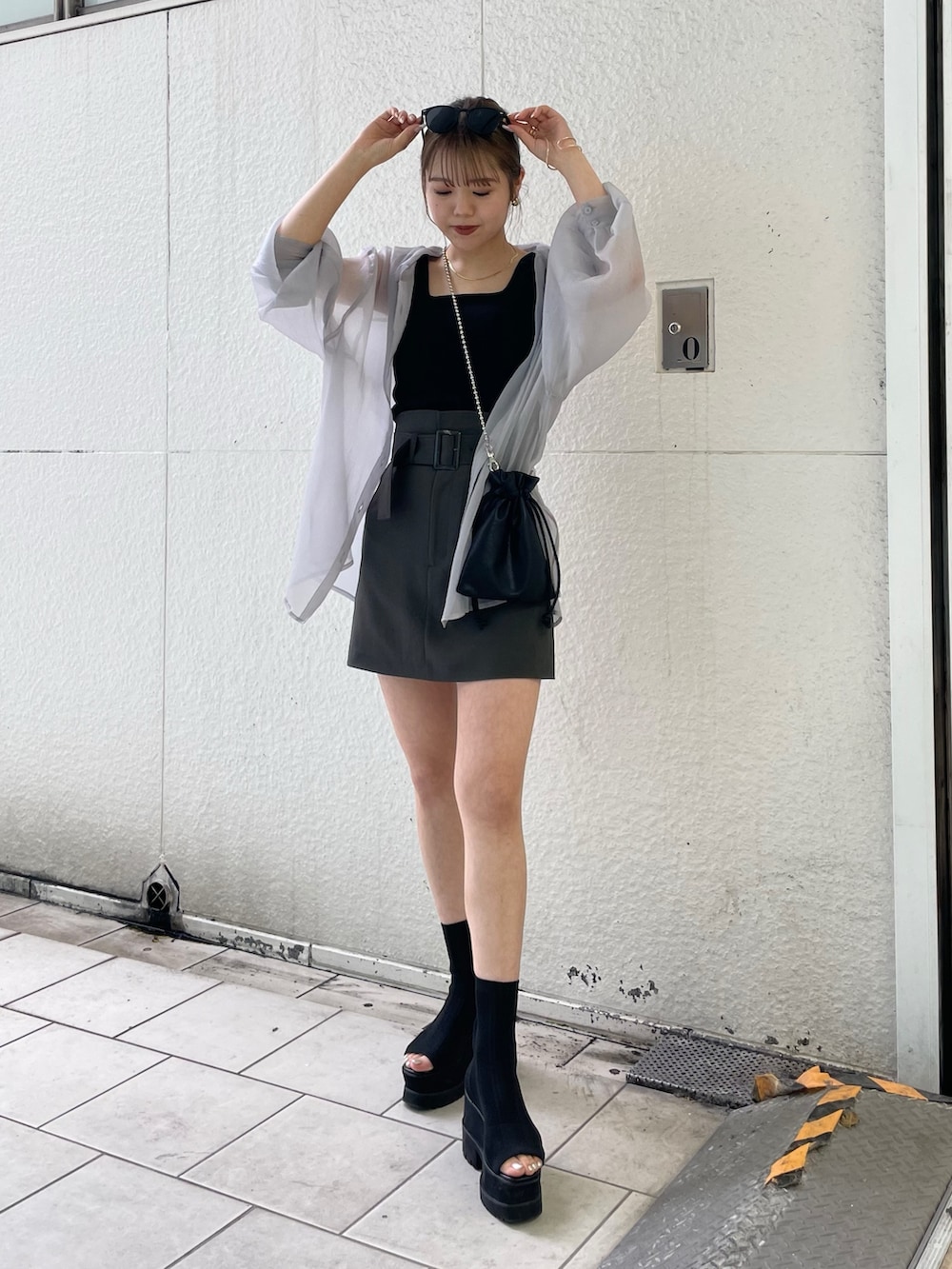 グレー系のシャツ/ブラウス、ブラック系のニット/セーター、グレー系のスカートを着用したレディースの春コーディネートの2枚目の写真