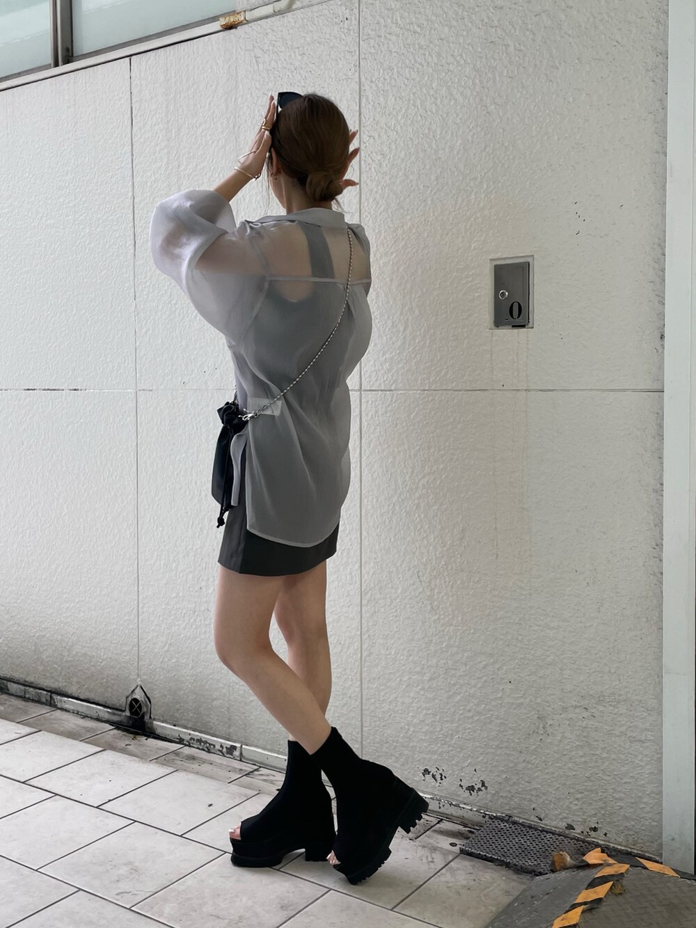 グレー系のシャツ/ブラウス、ブラック系のニット/セーター、グレー系のスカートを着用したレディースの春コーディネートの3枚目の写真