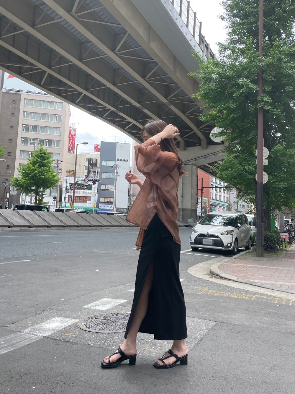 ブラック系のハンドバッグ、ブラック系のサンダル、ブラウン系のシャツ/ブラウスを着用したレディースの春コーディネートの2枚目の写真