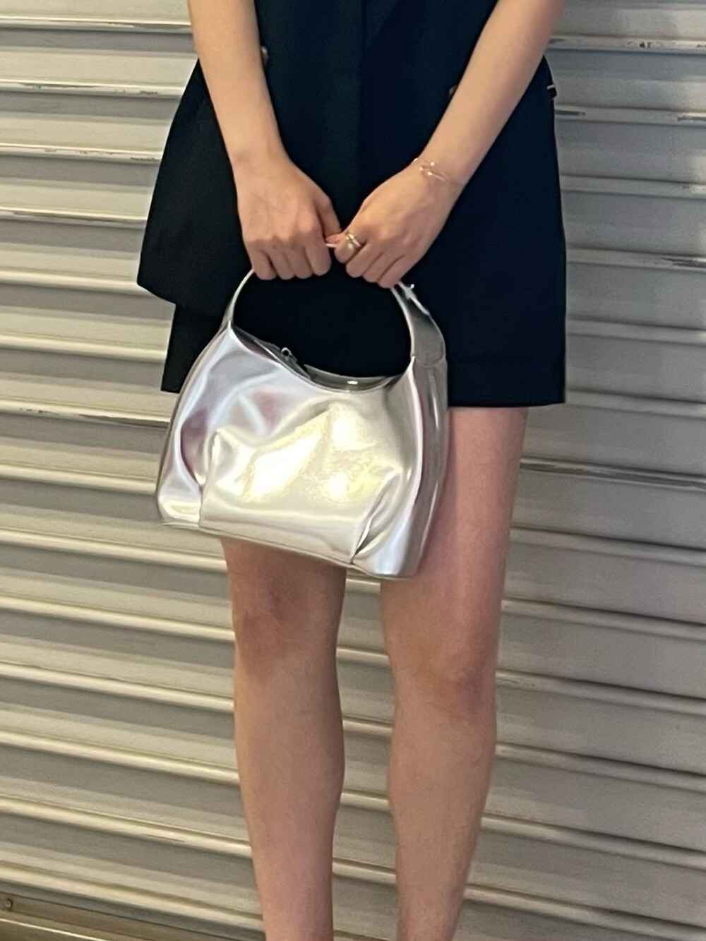 ブラック系のスカート、ホワイト系のタンクトップ、シルバー系のハンドバッグを着用したレディースの夏コーディネートの8枚目の写真