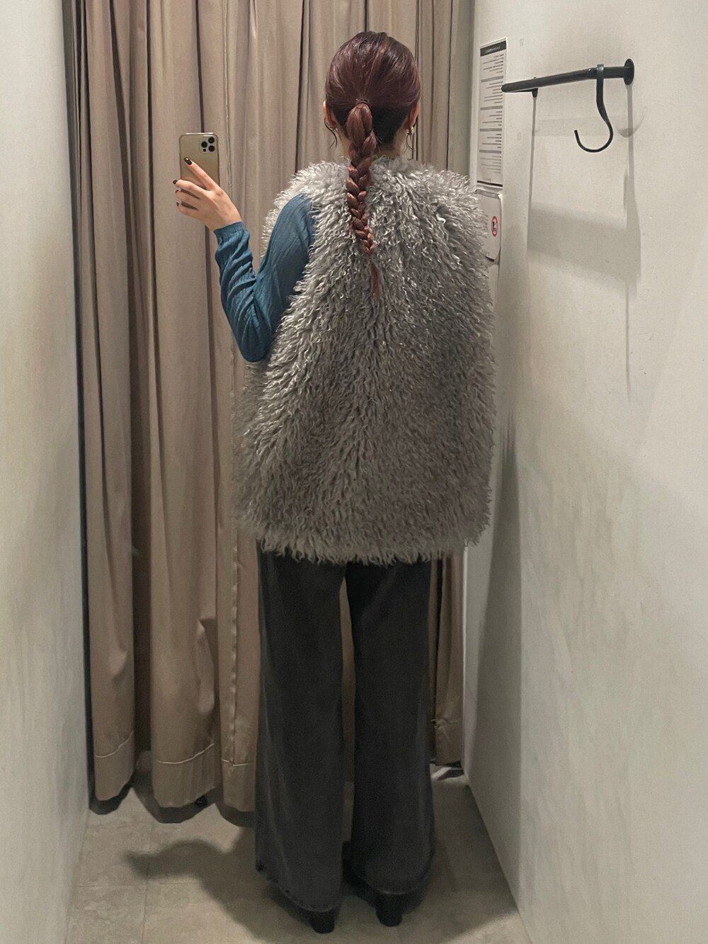 ブルー系のデニムパンツ、グレー系のベスト、ブルー系のニット/セーターを着用したレディースの秋コーディネートの3枚目の写真