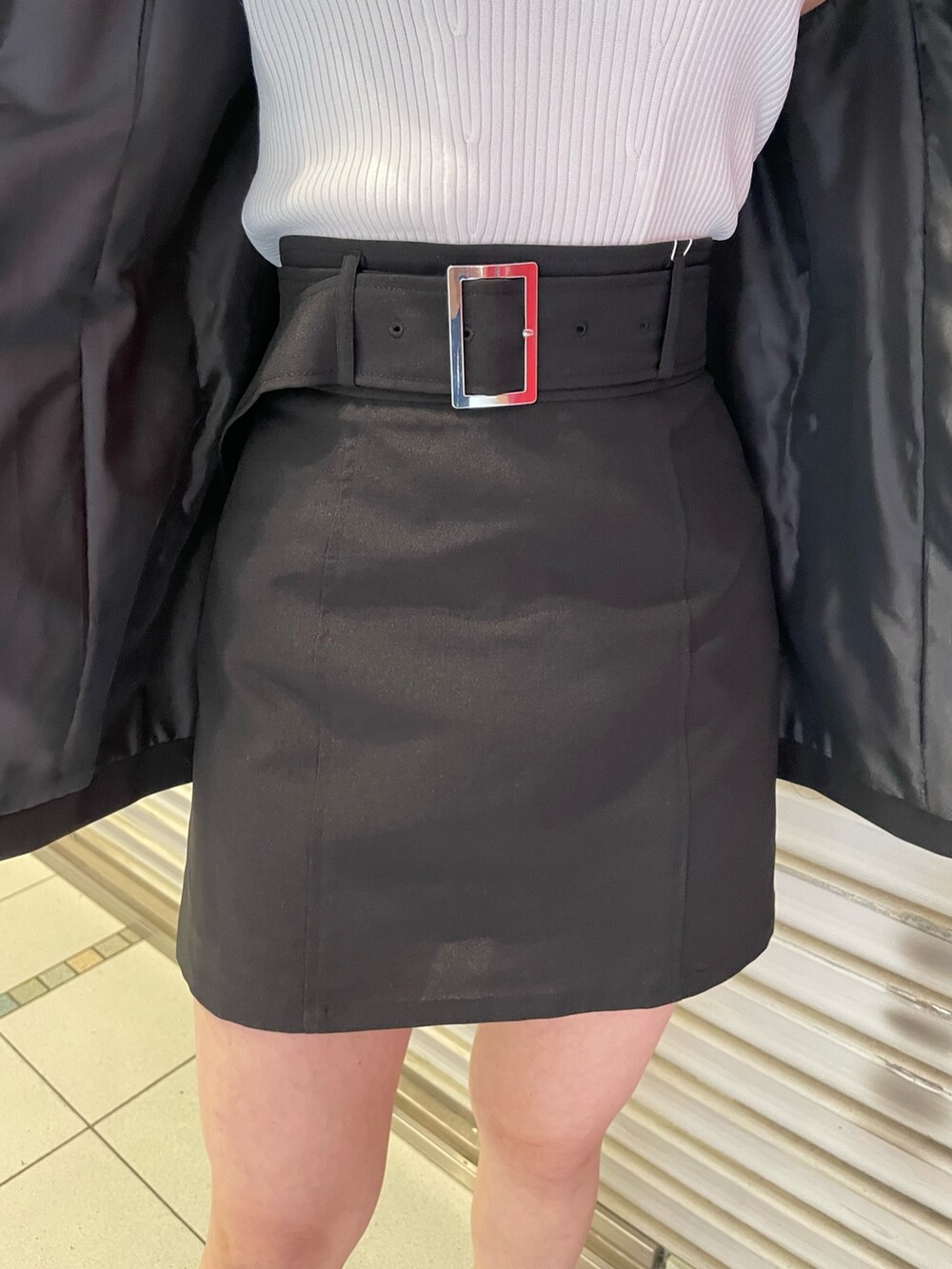 ブラック系のスカート、ホワイト系のタンクトップ、シルバー系のハンドバッグを着用したレディースの夏コーディネートの6枚目の写真