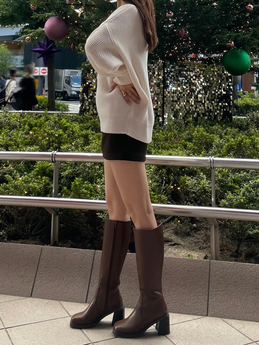 ホワイト系のニット/セーター、ブラウン系のスカート、ブラウン系のブーツを着用したレディースの秋コーディネートの3枚目の写真