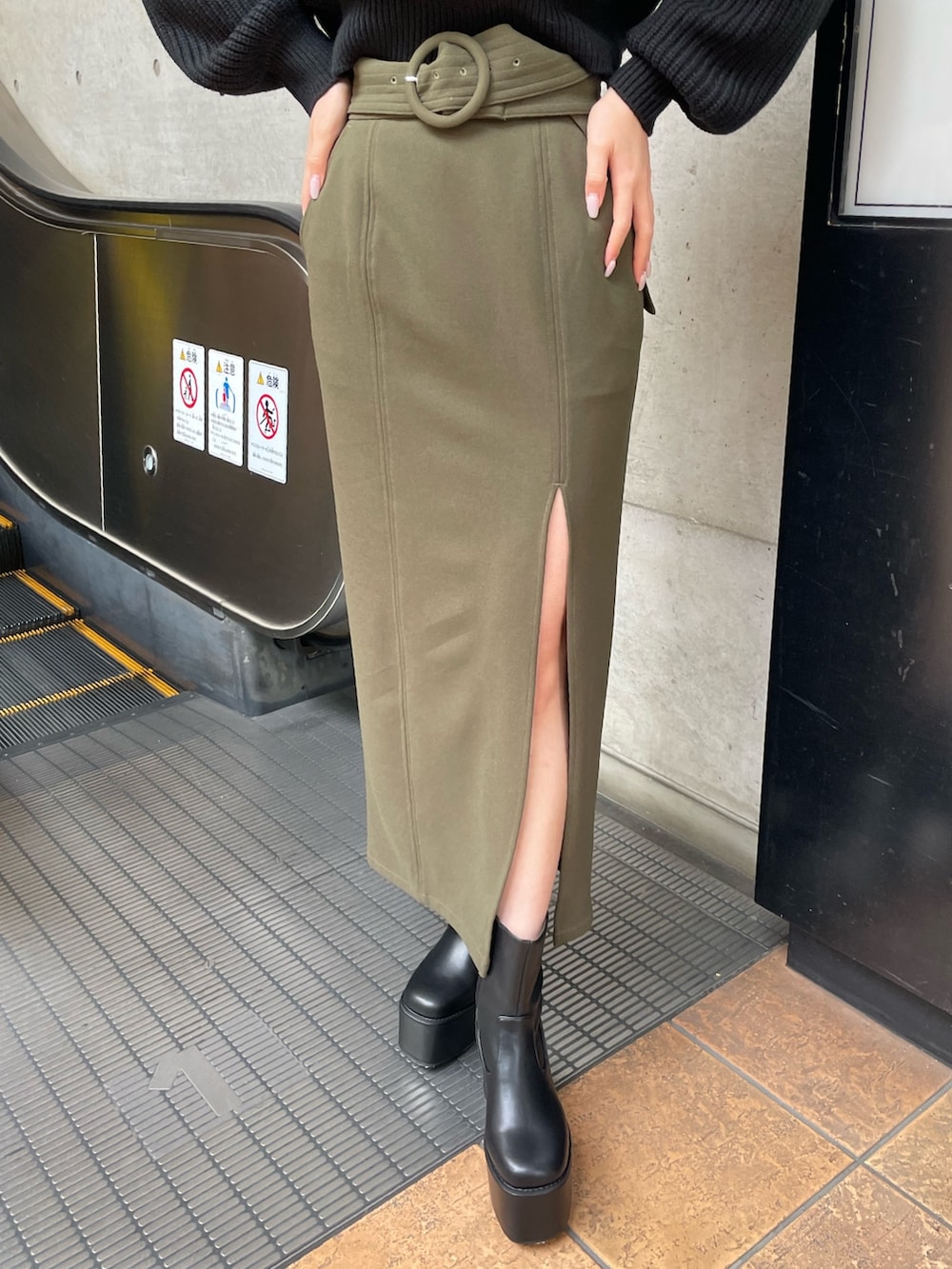 ブラック系のブーツ、グリーン系のスカート、ブラック系のニット/セーターを着用したレディースの冬コーディネートの7枚目の写真