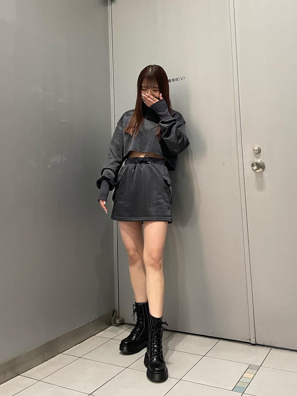 ブラック系のブーツ、グレー系のスカート、グレー系のTシャツ/カットソーを着用したレディースの冬コーディネートの2枚目の写真