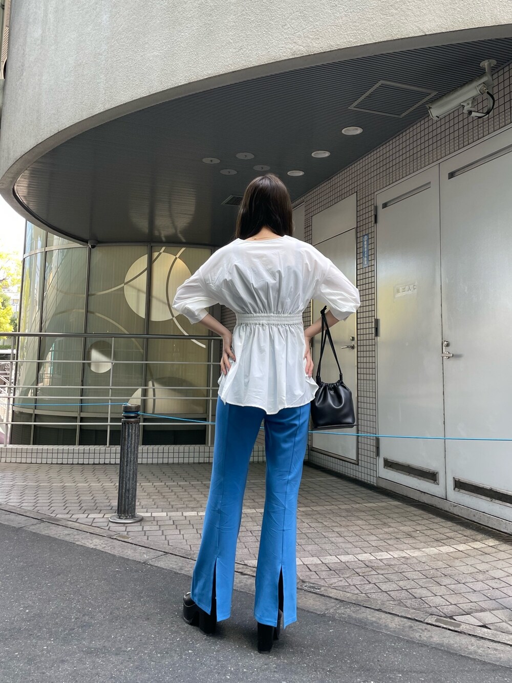 ホワイト系のシャツ/ブラウス、ブルー系のスウェットパンツ、ブラック系のハンドバッグを着用したレディースの春コーディネートの4枚目の写真