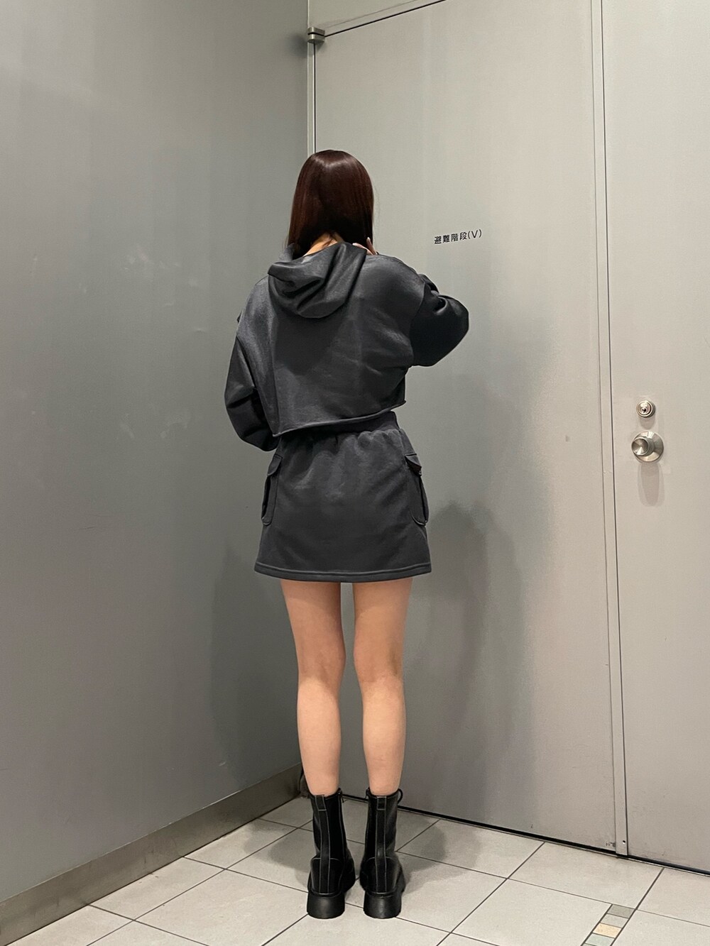 ブラック系のブーツ、グレー系のスカート、グレー系のTシャツ/カットソーを着用したレディースの冬コーディネートの4枚目の写真