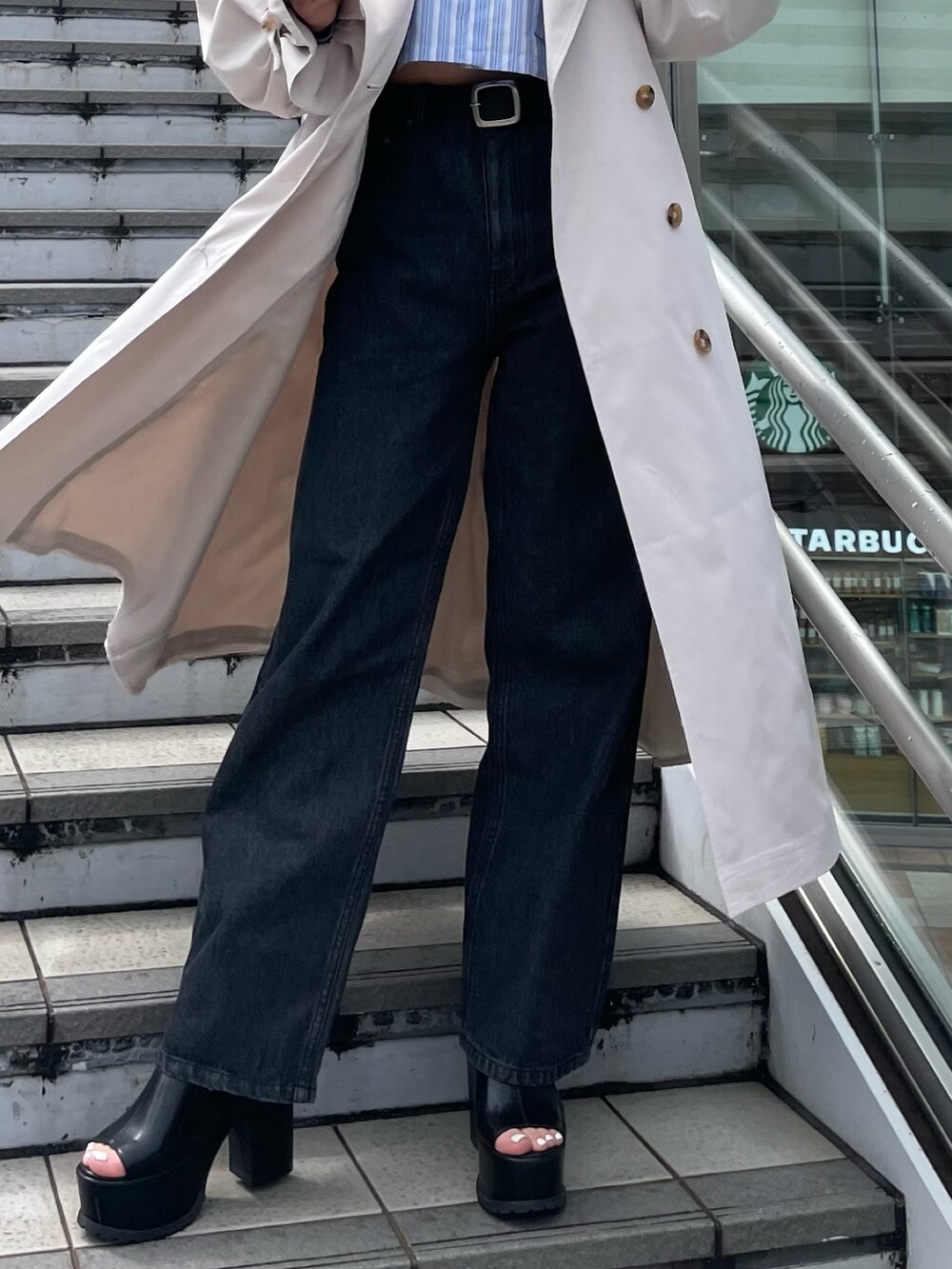 ホワイト系のトレンチコート、ブラック系のサンダル、ブラック系のデニムパンツを着用したレディースの春コーディネートの8枚目の写真