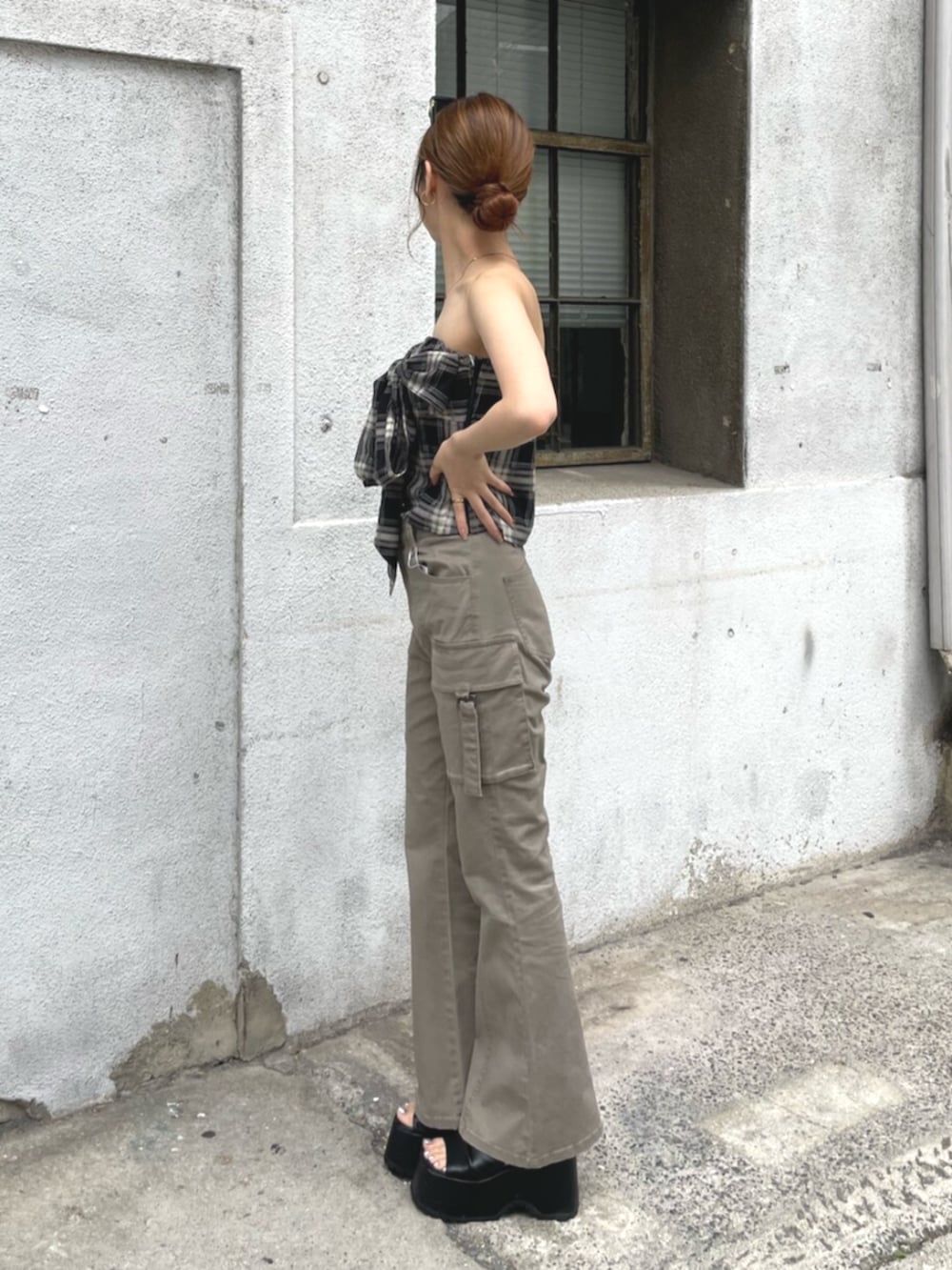 ベージュ系のカーゴパンツ、ブラック系のTシャツ/カットソー、ブラック系のブーツを着用したレディースの夏コーディネートの2枚目の写真